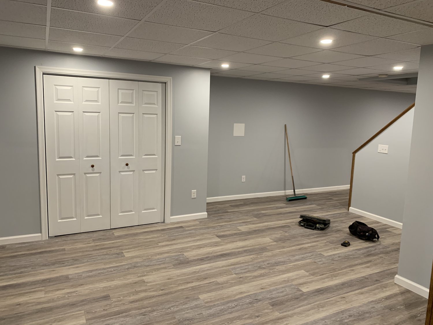 Finished basement living area with new flooring and ceiling